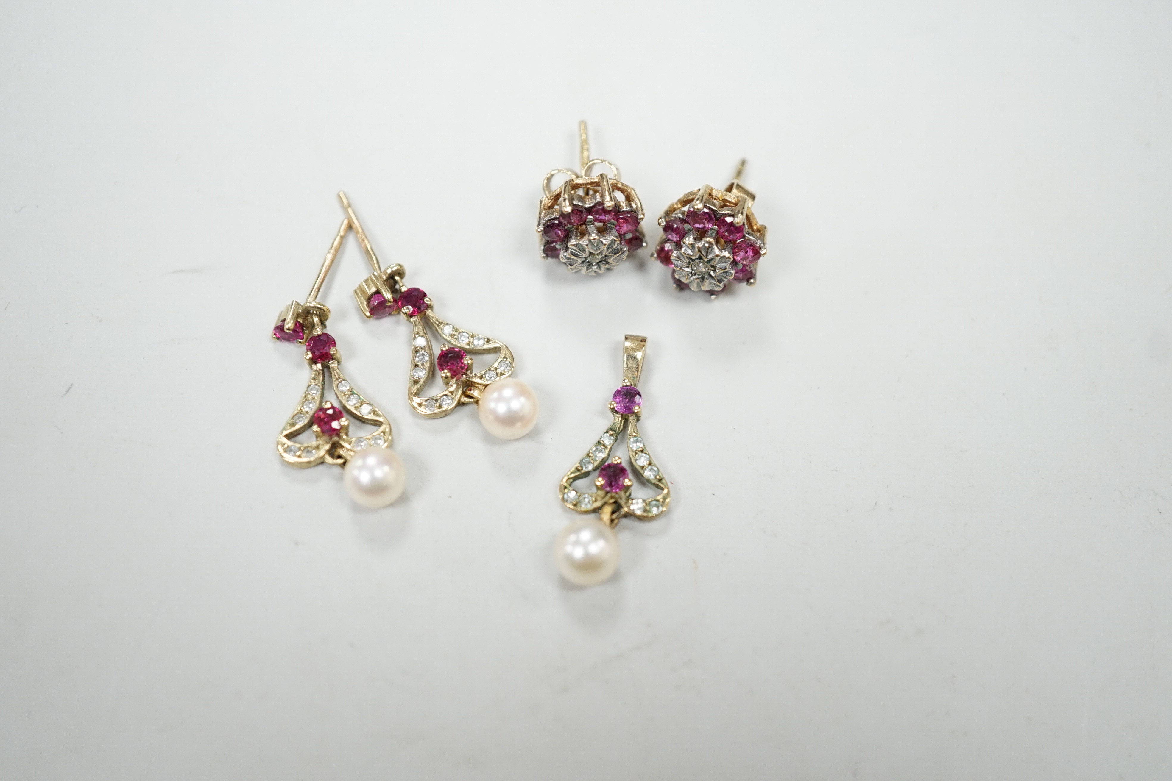 A modern 9ct gold, ruby, diamond and cultured pearl set drop pendant, 22mm and a pair of matching earrings, together with a pair of ruby and diamond cluster set ear studs, gross weight 5.7 grams.